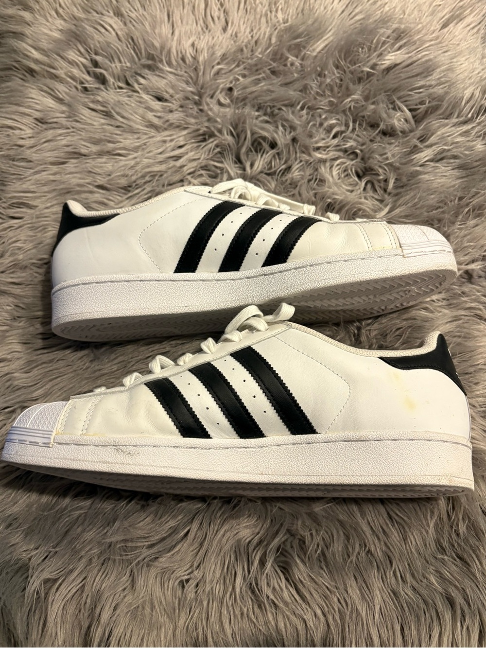 adidas Menโs White Shell Toe Sneakers with Black Three-Stripes